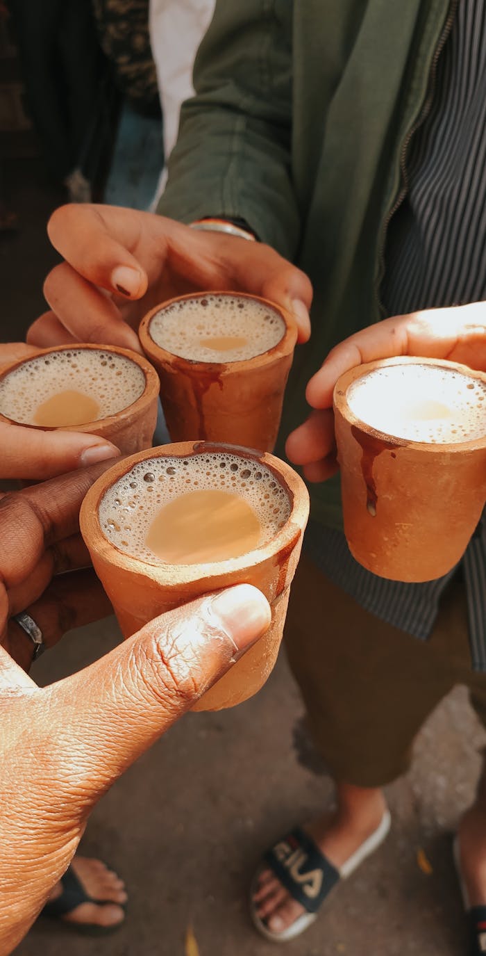Friends toasting with traditional masala chai in clay cups, capturing a vibrant cultural moment.